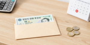 반환일시금과 국민연금 복원을 고민하는 모습을 상징하는 이미지, 계산기와 달력, 동전이 놓인 책상