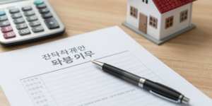 주택연금 계약서와 계산기, 주택 모형이 놓인 책상 위의 모습